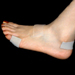 PediFix Visco Gel Silicone Self-Adhesive Sheeting cut into various sizes and stuck to various places on the foot including the pinky to the instep and the heel